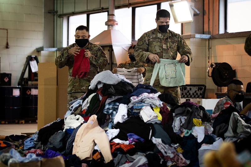 U.S. Air Force Airmen and volunteers fold and sort donated goods for evacuees in Ramstein Air Base, Germany, at Royal Air Force Lakenheath, England, Aug. 30, 20