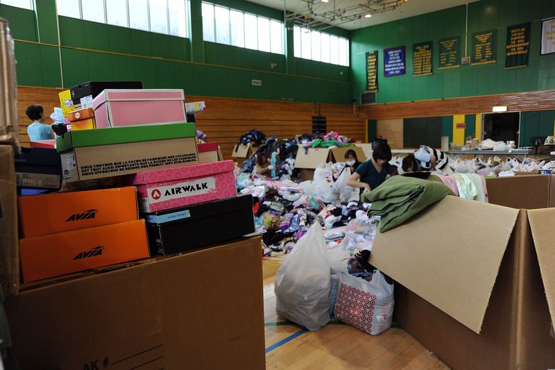 Volunteers sort through goods and materials donated to Japan by listeners of the "Ron and Don" radio show at Naval Air Facility Misawa, Japan, June 24, 2011. Th